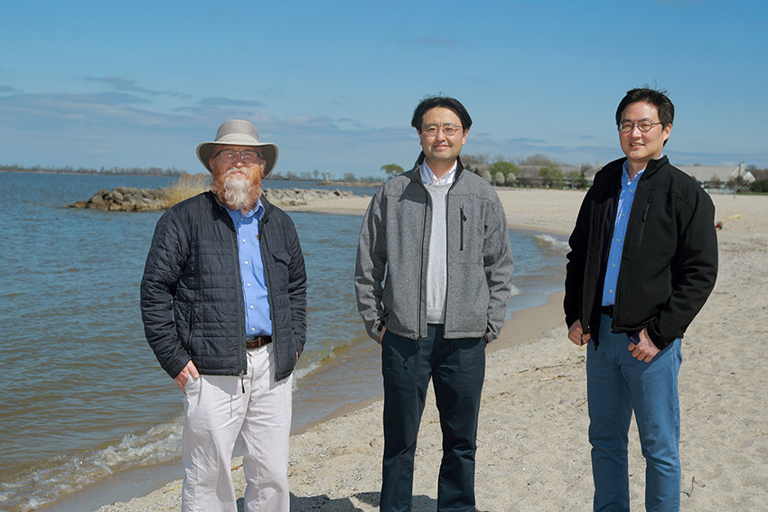 Youngwoo Seo, Ph.D., Thomas Bridgeman, Ph.D., and Dae-Wook Kang, Ph.D., standing on a beach